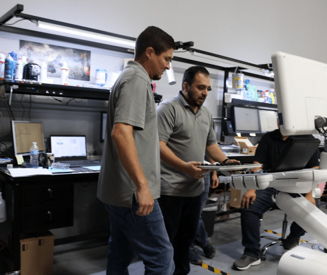 Ultrasound refurbishing technicians installing GE ultrasound keyboard